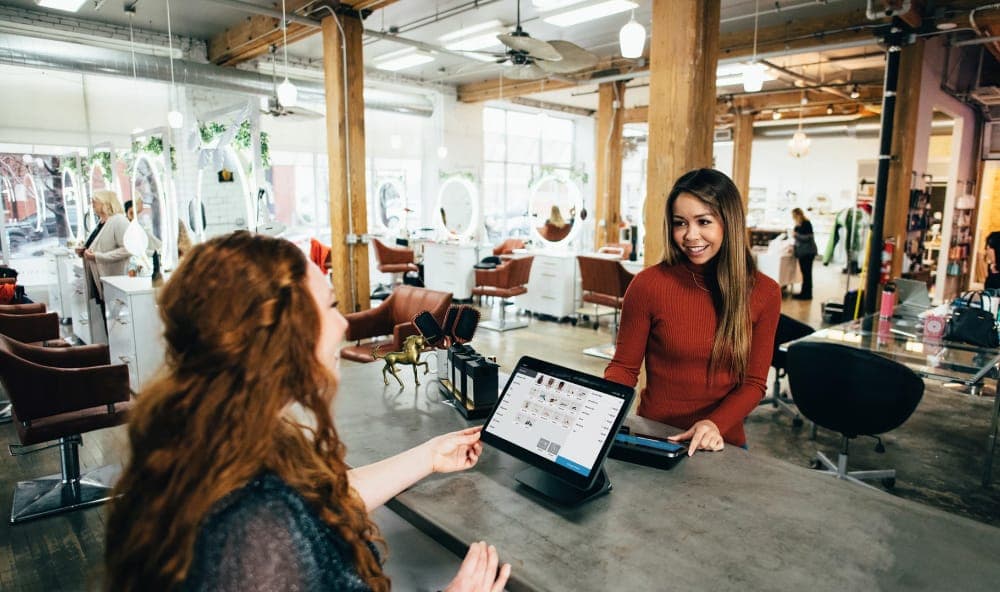 Staff member helping a customer with a tablet